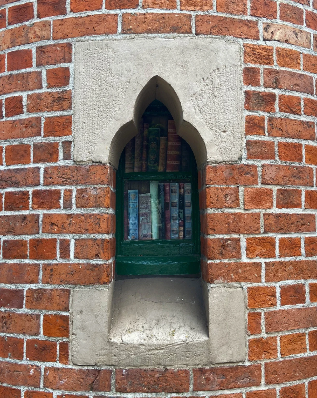 Gothic-style window with books, reflecting the historical architecture of the Schoolhouse Hotel
