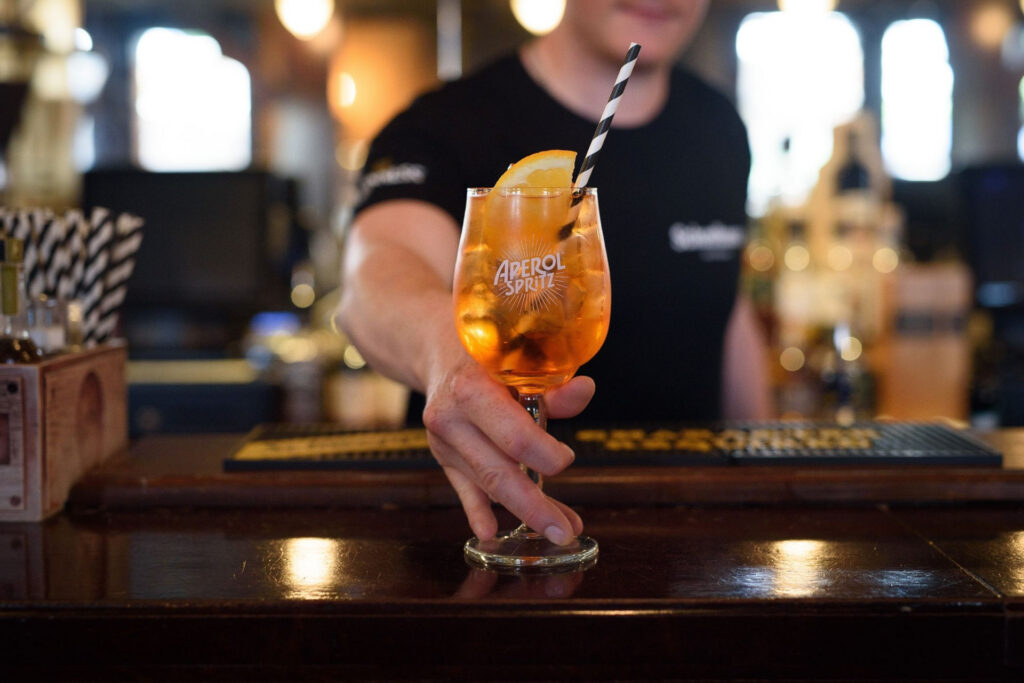 Bartender-presenting-cocktail-at-bar-spring-summer