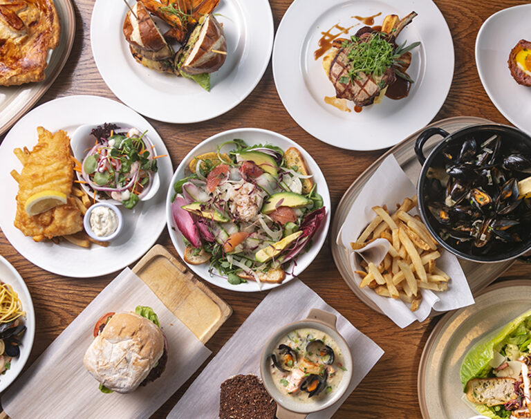 Overhead view of Gastrobar dishes including fish and chips, mussels, steak, burgers and salads