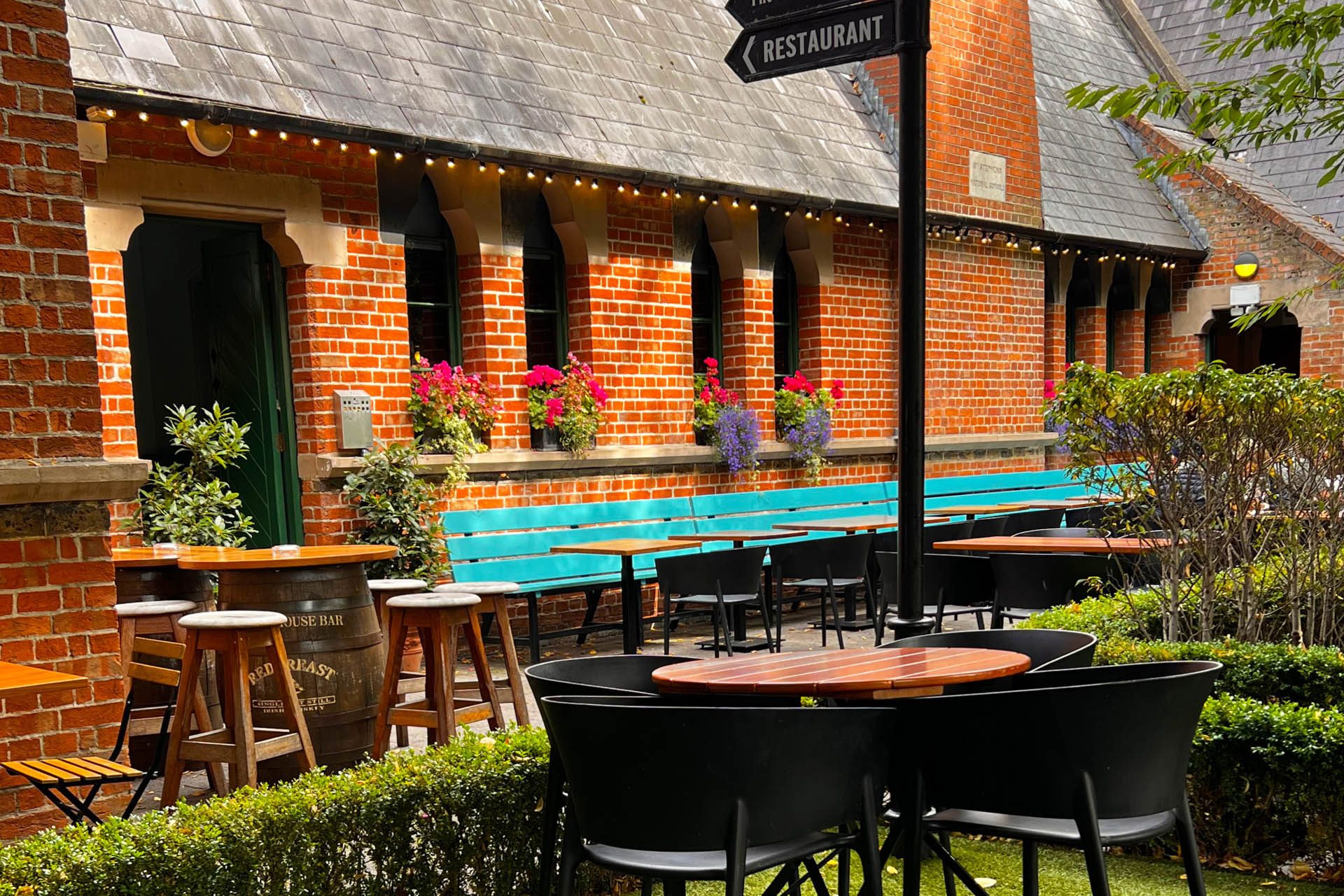 Courtyard seating with a signpost to hotel reception, the Schoolhouse Bar and restaurant